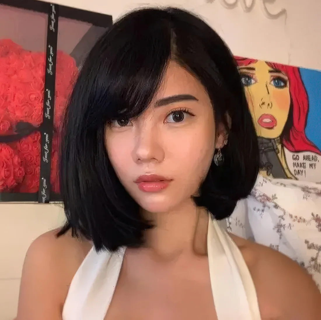Black asymmetrical bob with side bangs, a lot of volume and curled ends.