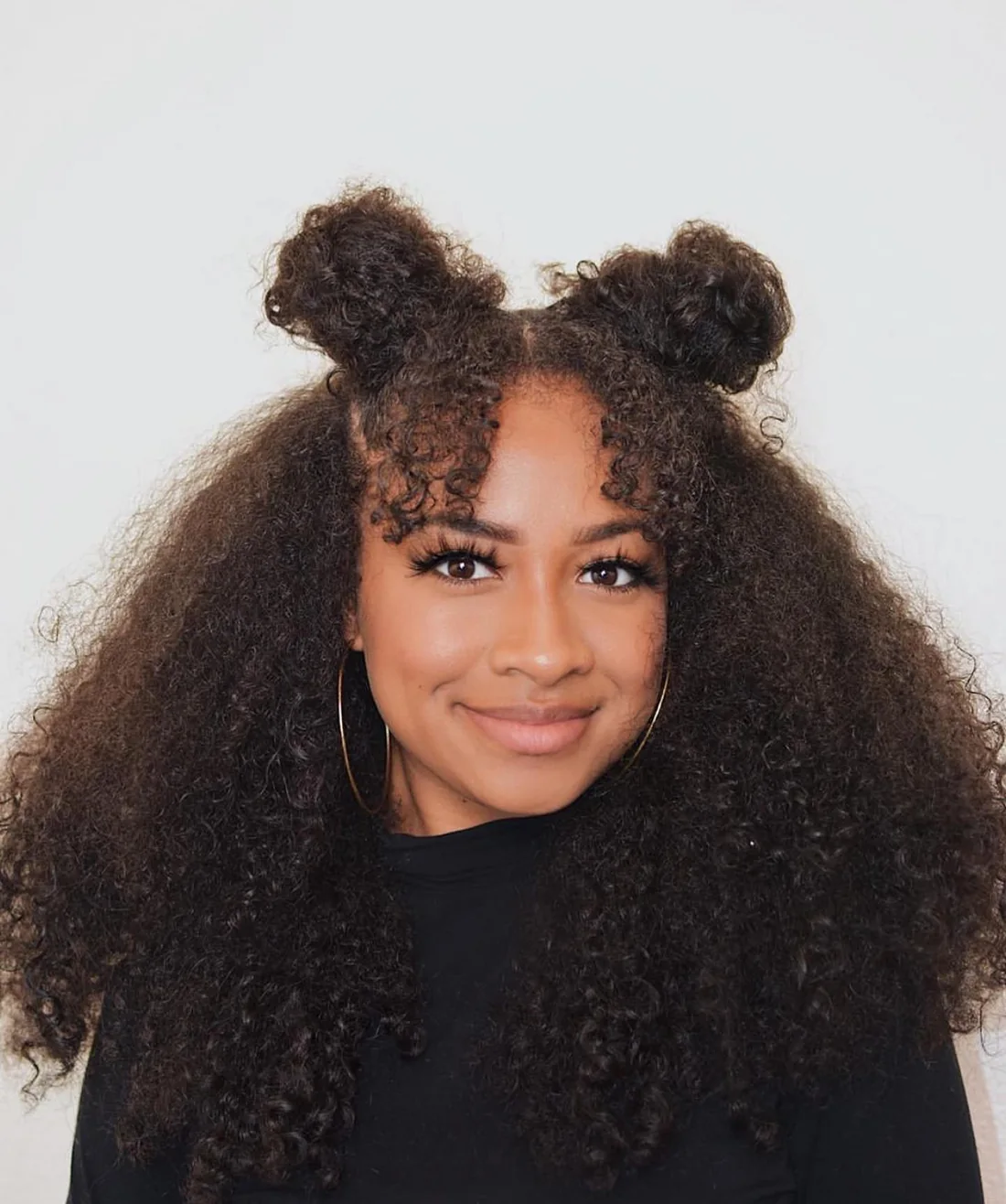 Photo showing half-up Curly Space Buns, with the hairstyle clearly visible.
