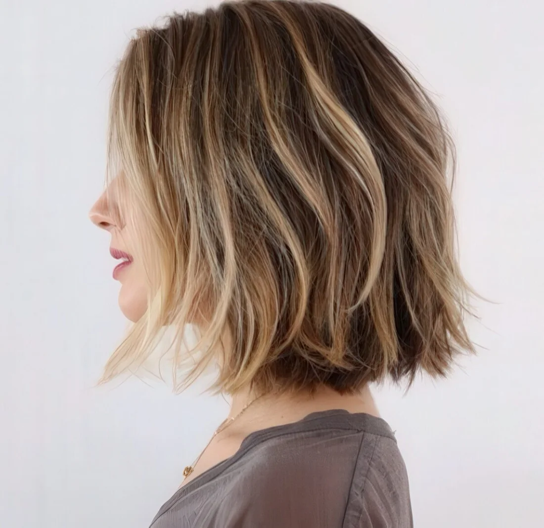 Wavy short brown bob with blonde balayage highlights for creating a volume.