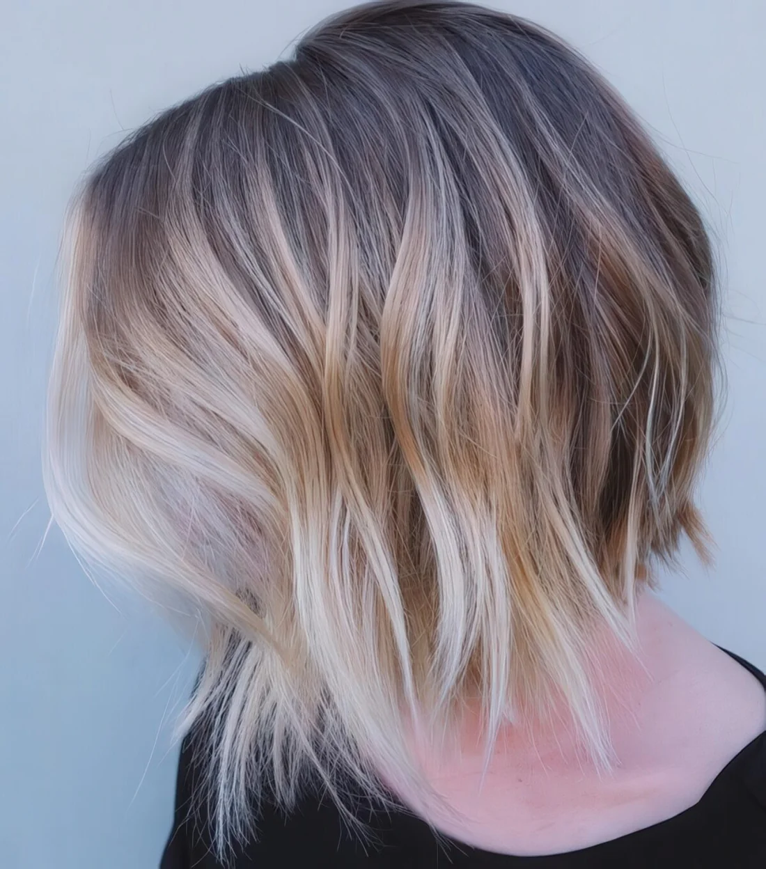 Brown bob haircut with an uneven edge and blond balayage for a mind blowing look.