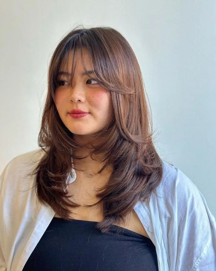 shoulder wavy chestnut layers with curtain fringe shown as a bangs for round face idea