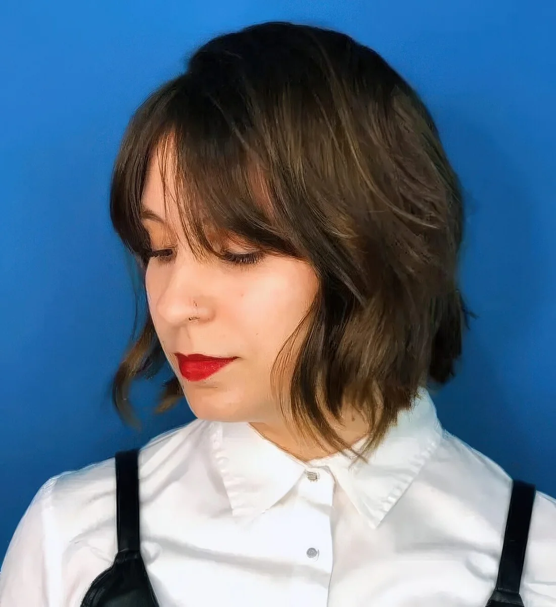Dark brunette shaggy bob with Bardot bangs and a bit of highlights.