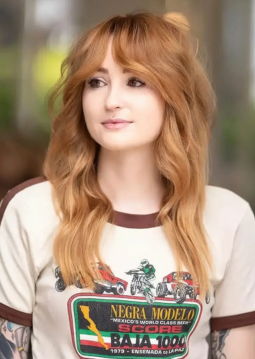 Long honey blonde hair with waves and a lot of volume, with front mid partition Bardot fringe.