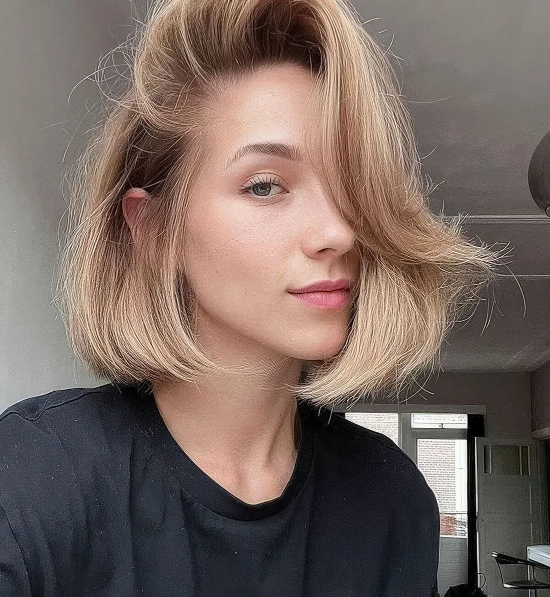 Midi bob in a soft shade of blonde styled as a baroque one, with curled ends and a lot of volume.