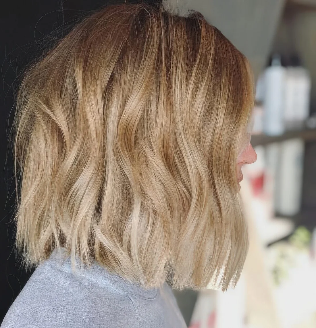 Wavy gold blonde long bob with a darker root.