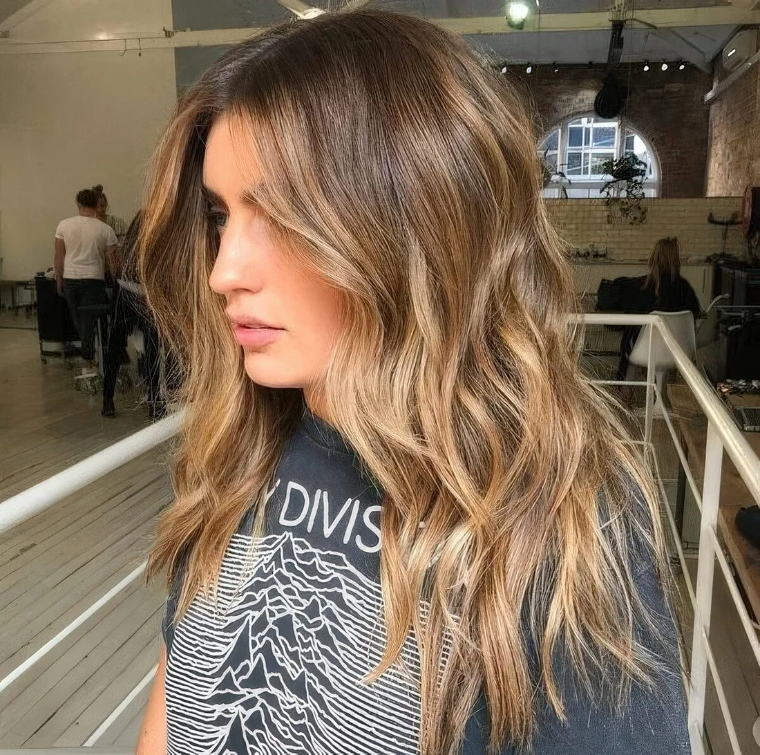 Brown hair with a pop of honey blonde placed to frame the face and with an angled scheme.