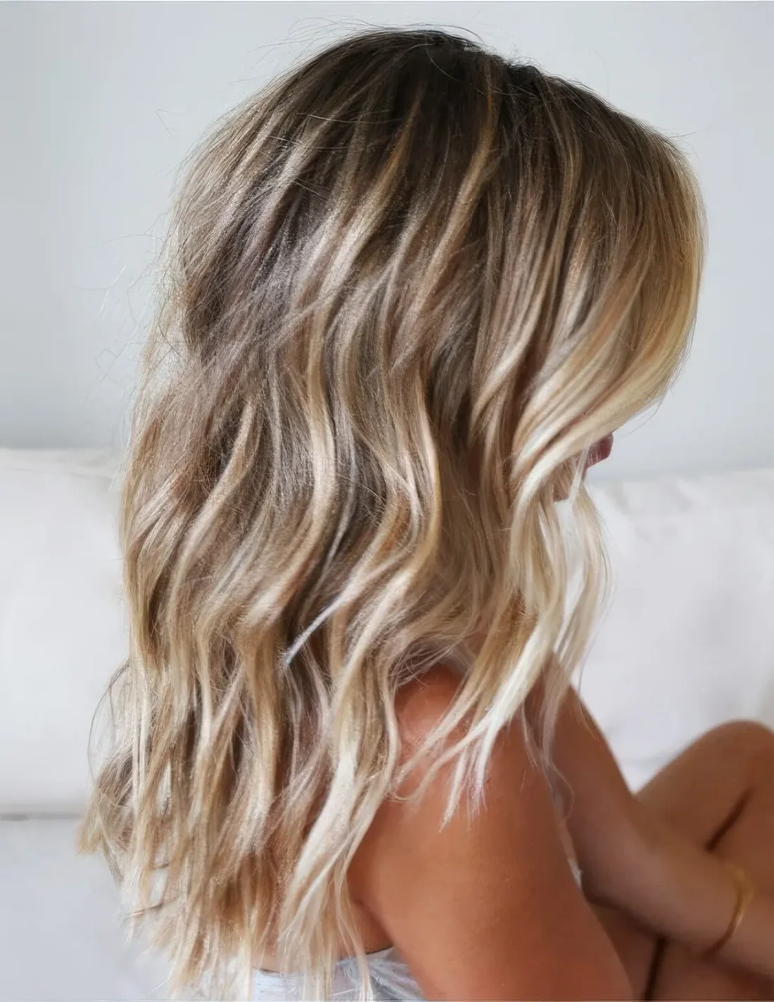 Brunette medium-length hair with blonde balayage and beach waves.