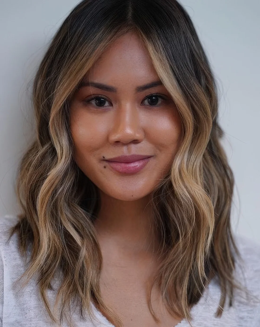 Dark brown, almost black hair with delicate caramel and bronde balayage and a bit of waves for a lovely beach look.