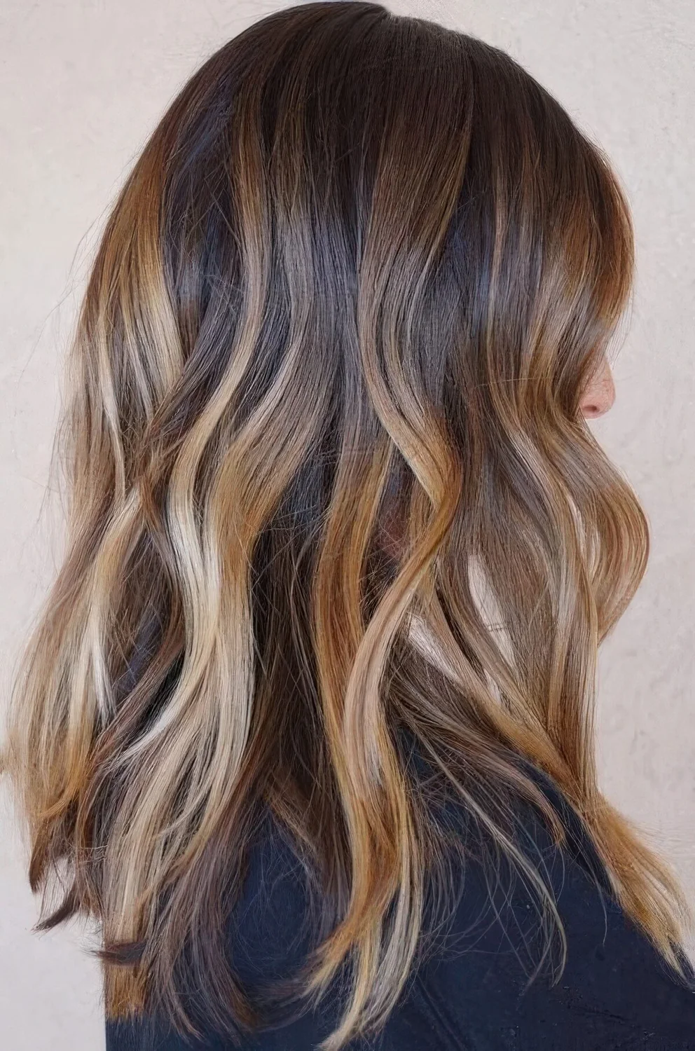 Dark brunette hair with a caramel balayage and blonde balayage plus beach waves.
