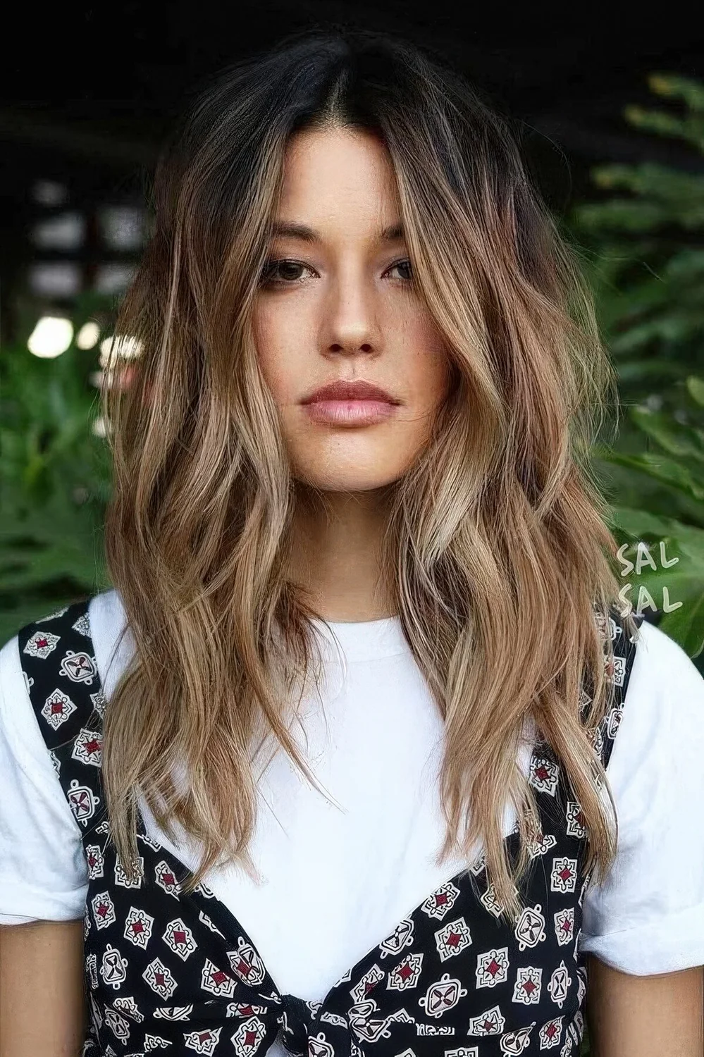 Dark brunette hair with beautiful and messy waves and sunkissed balayage.