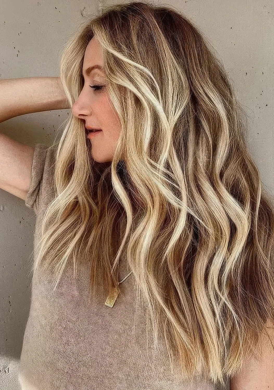 Dimensional beach blonde balayage on bronde hair and beach waves.