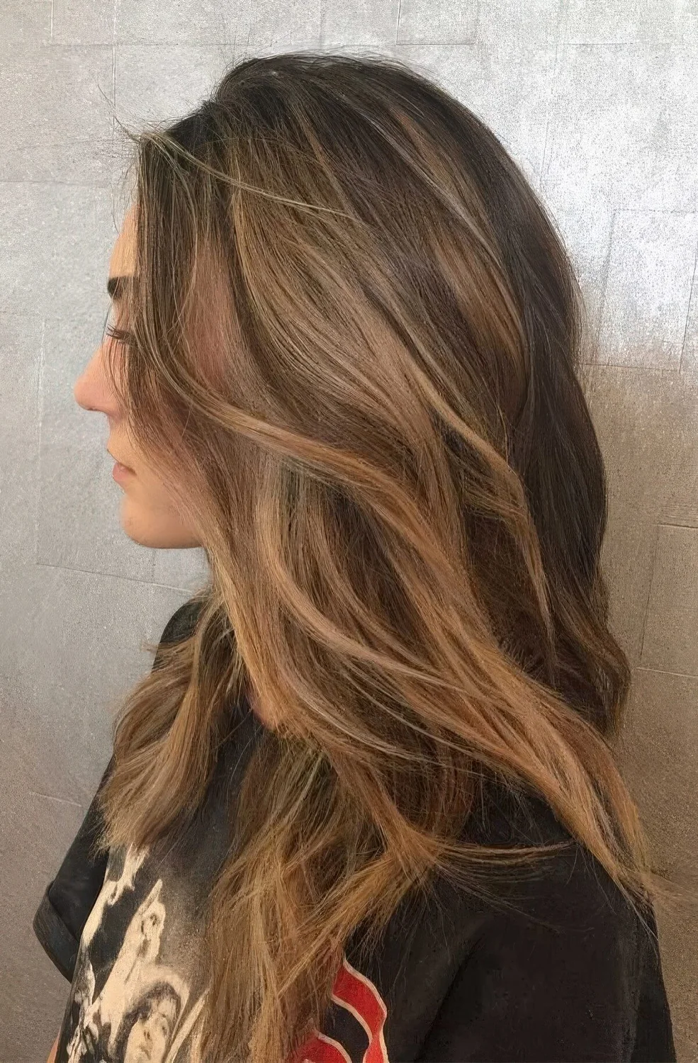 Long brunette hair with caramel balayage and beach waves.