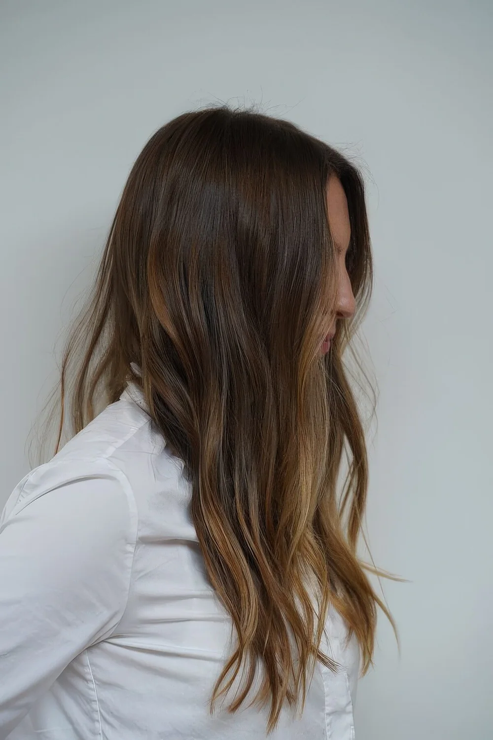 Long dark brunette hair with caramel balayage and slight beach waves.