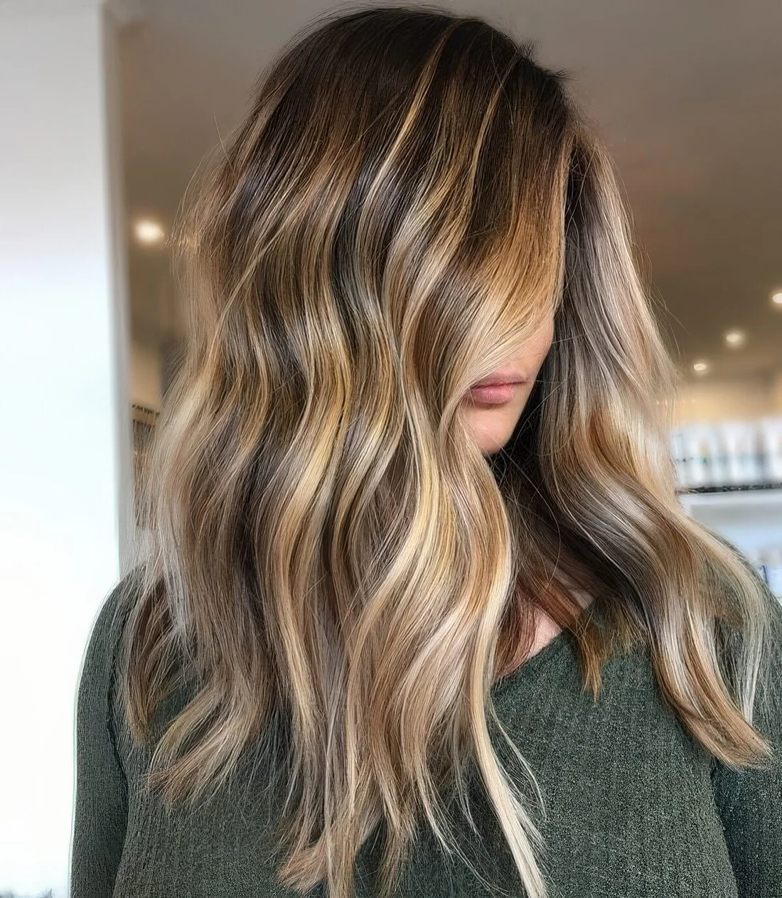 Long dark brunette hair with golde blonde balayage and beach waves.