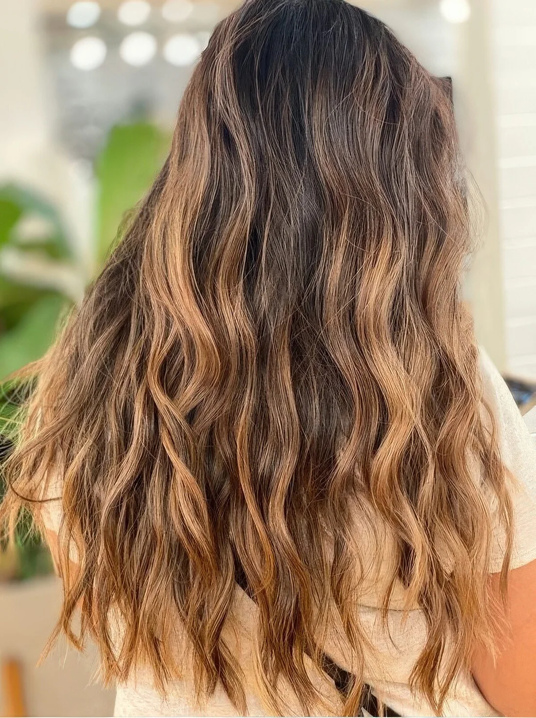 Long, dark brunette hair with caramel and bronde balayage and beach waves.
