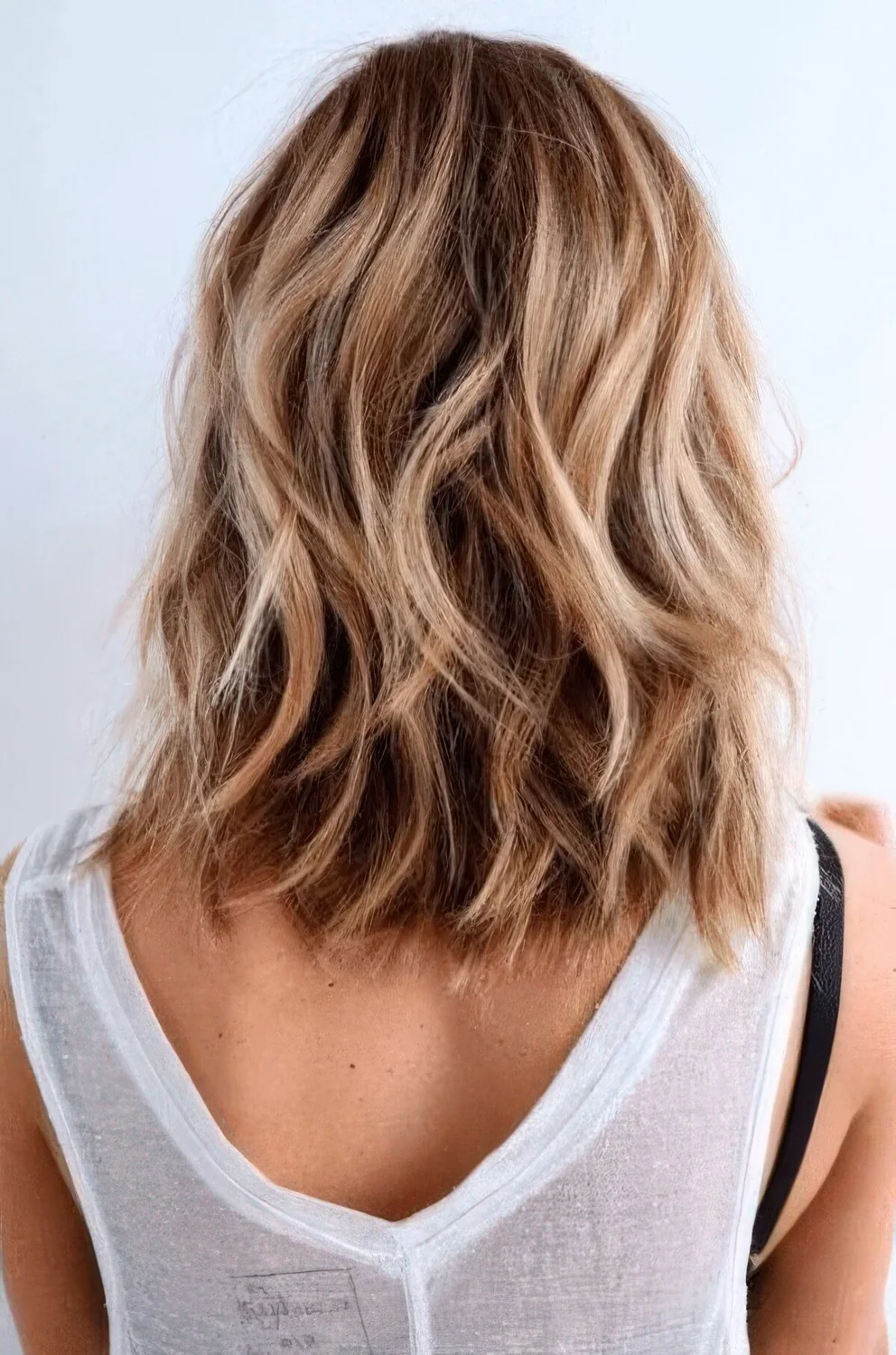 Medium-length bronde hair with balayage and beach waves.