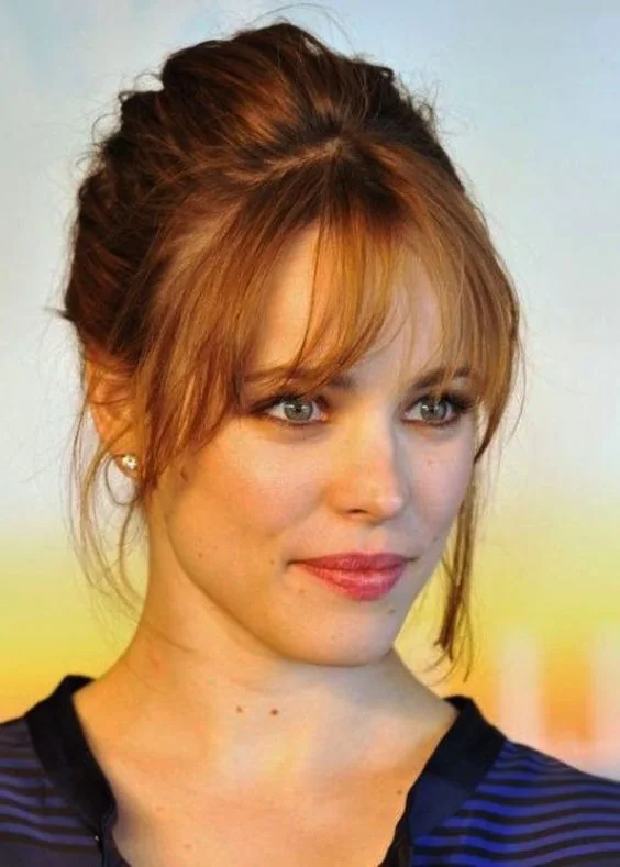Ginger messy updo with some locks down and cool Birkin bangs that accent the face in the best way possible.
