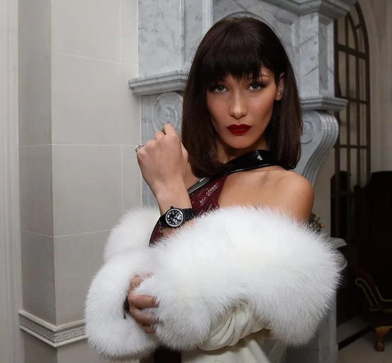 Bella Hadid wearing a brown shoulder-length bob with Birkin bangs for more contoured cheekbones, a bold maroon lip for a statement.