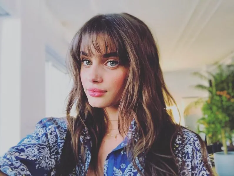 Model Taylor Hill styled her messy bangs with flushed cheeks and a berry stained lip.