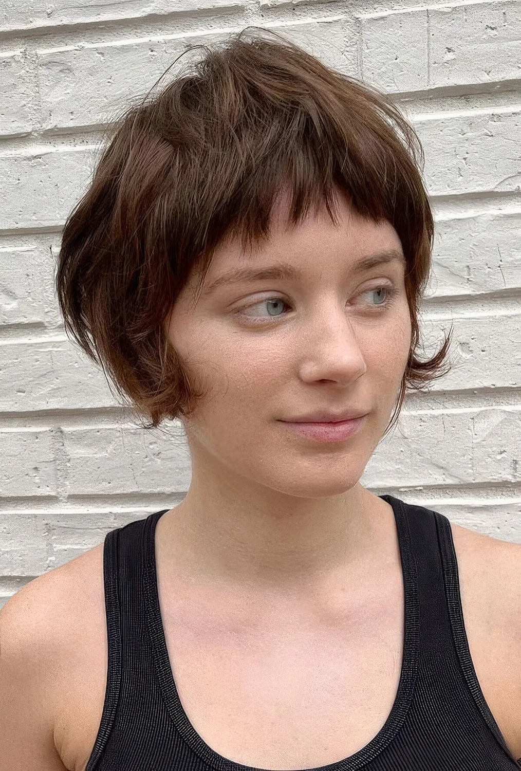 Brown bixie with a layers and textured touches, a short fringe and curved ends on the sides.