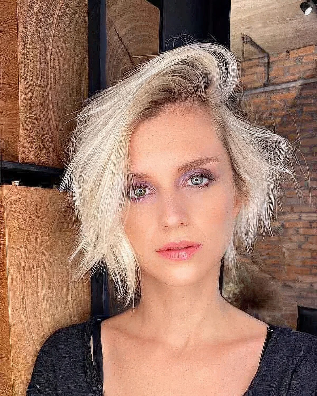 Messy blonde bixie haircut with deep side part.
