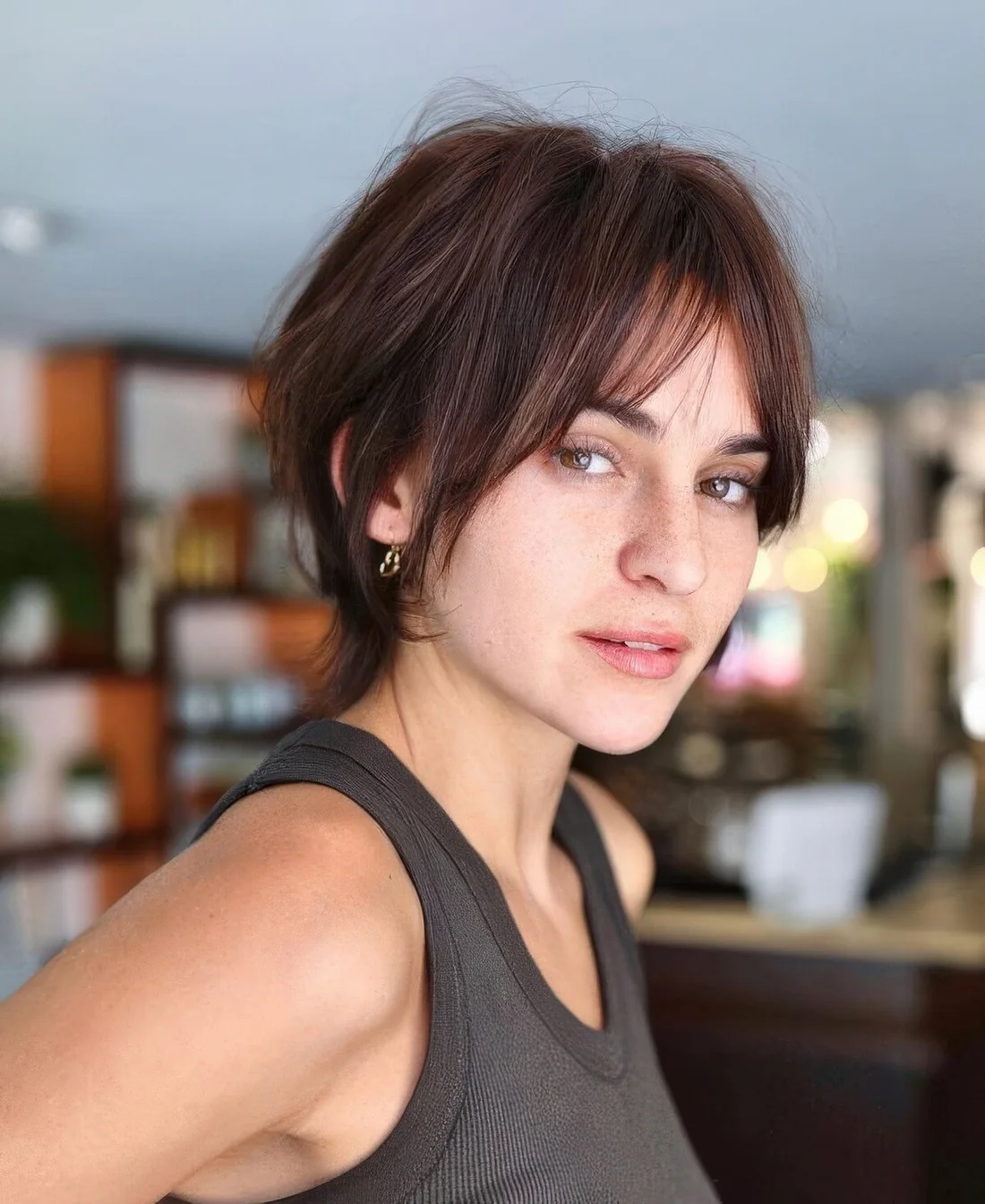 Messy chestnut bixie with bottleneck bangs, longer side hair and texture doesn't require much styling.