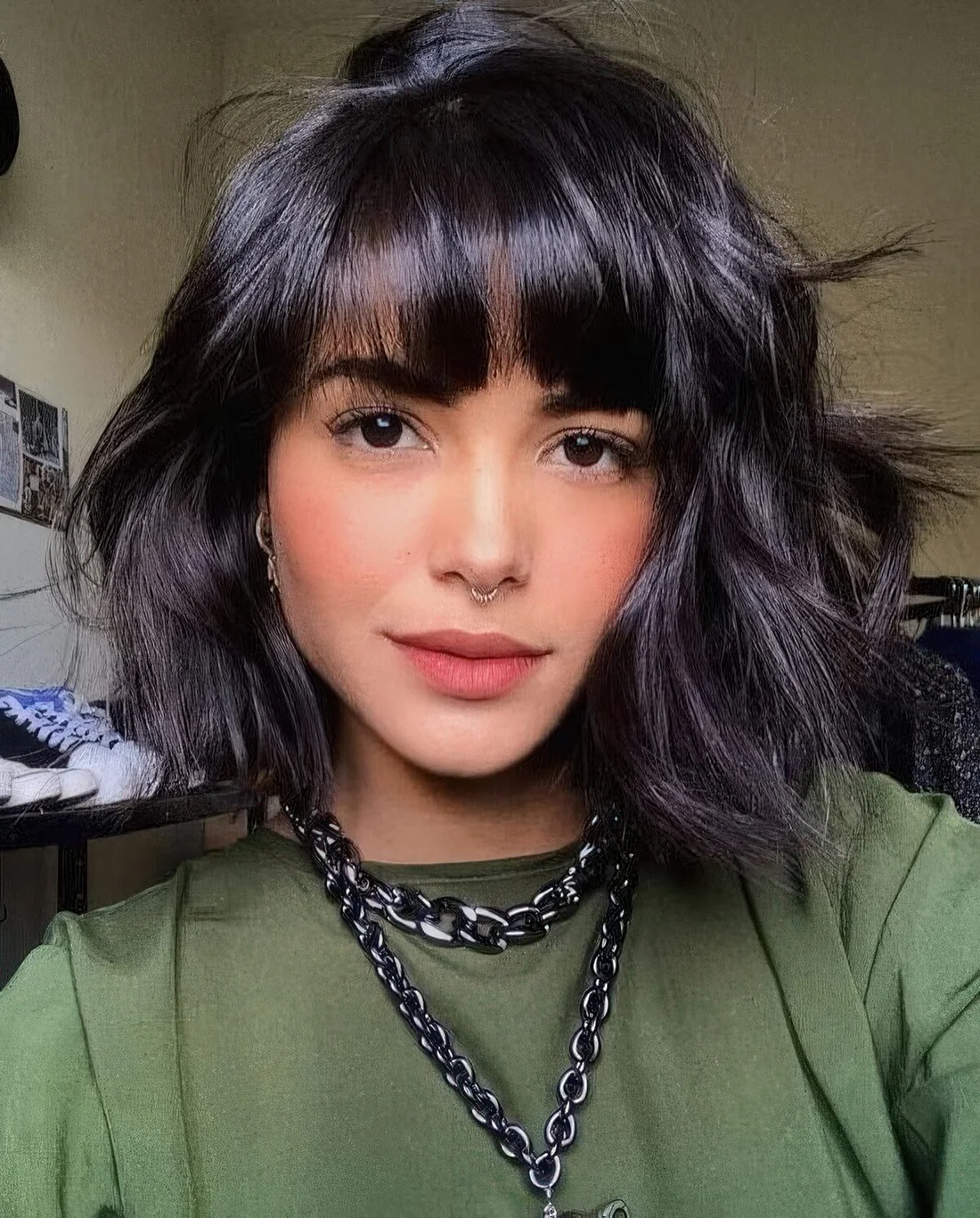 Black messy wavy chin-length bob with fringe bangs.