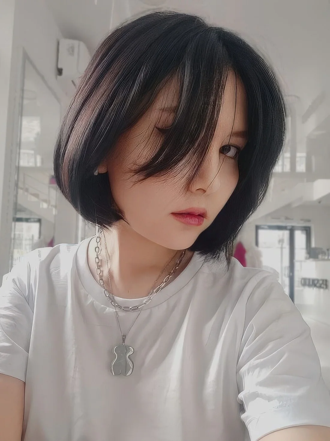 Black chin-length bob with long curtian bangs and a straight textured but crved ends.