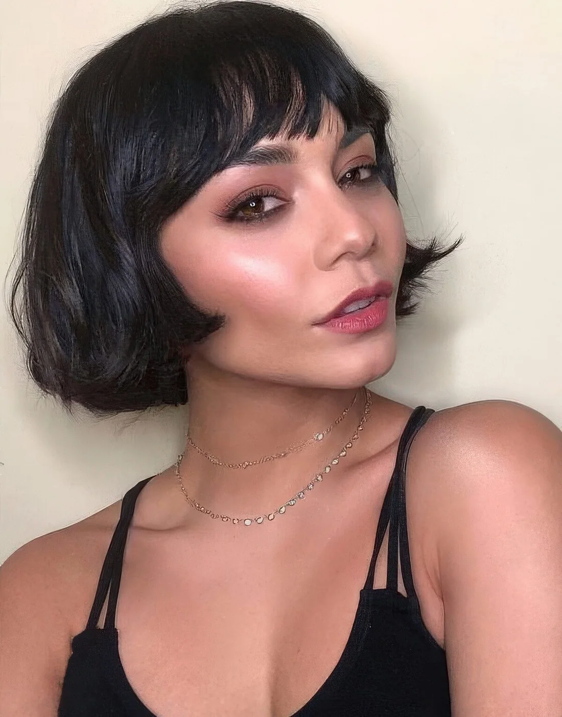 Black ear-length bob with wispy bangs and wavy hair.
