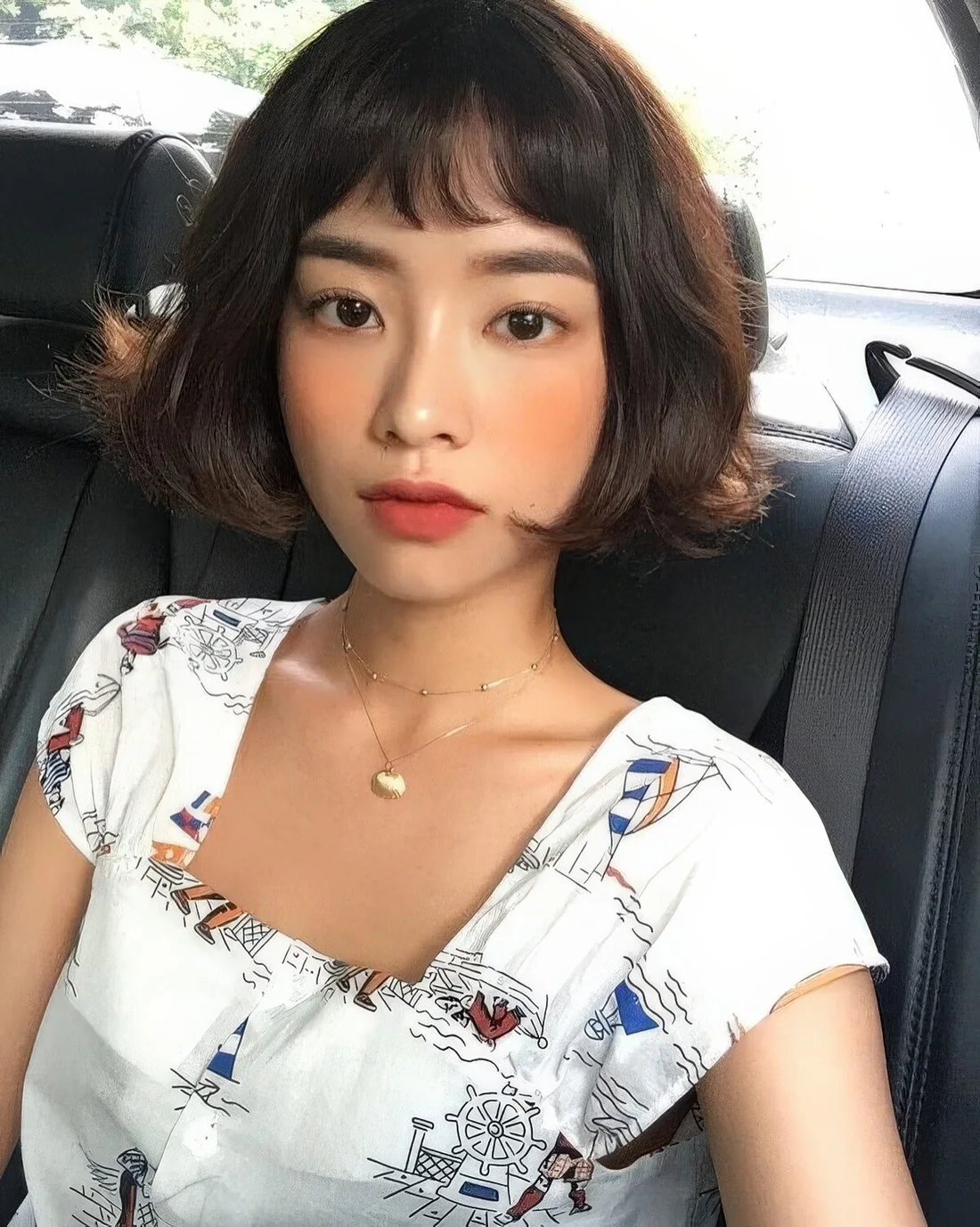 Black jaw-length wavy bob with wispy bangs.