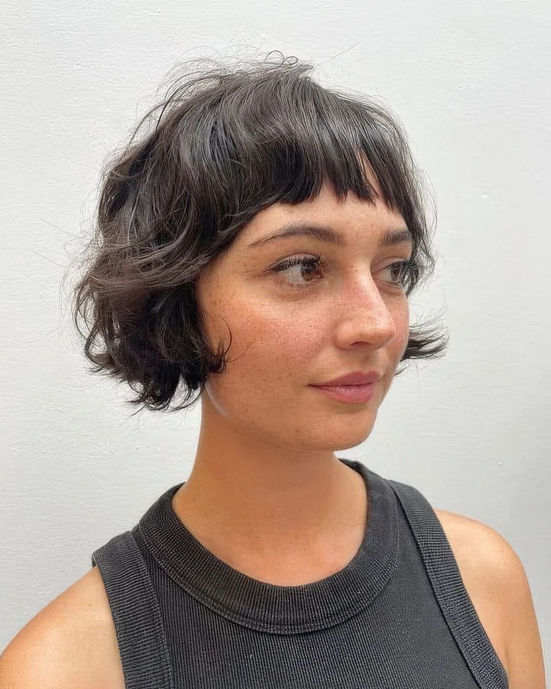 Black shaggy ear-length bob with wispy bangs.