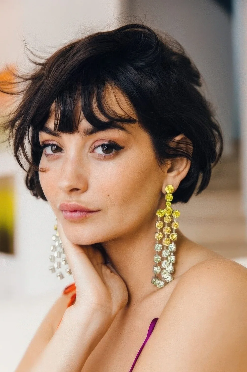 Black ear-length bob with wispy bangs and messy texture.