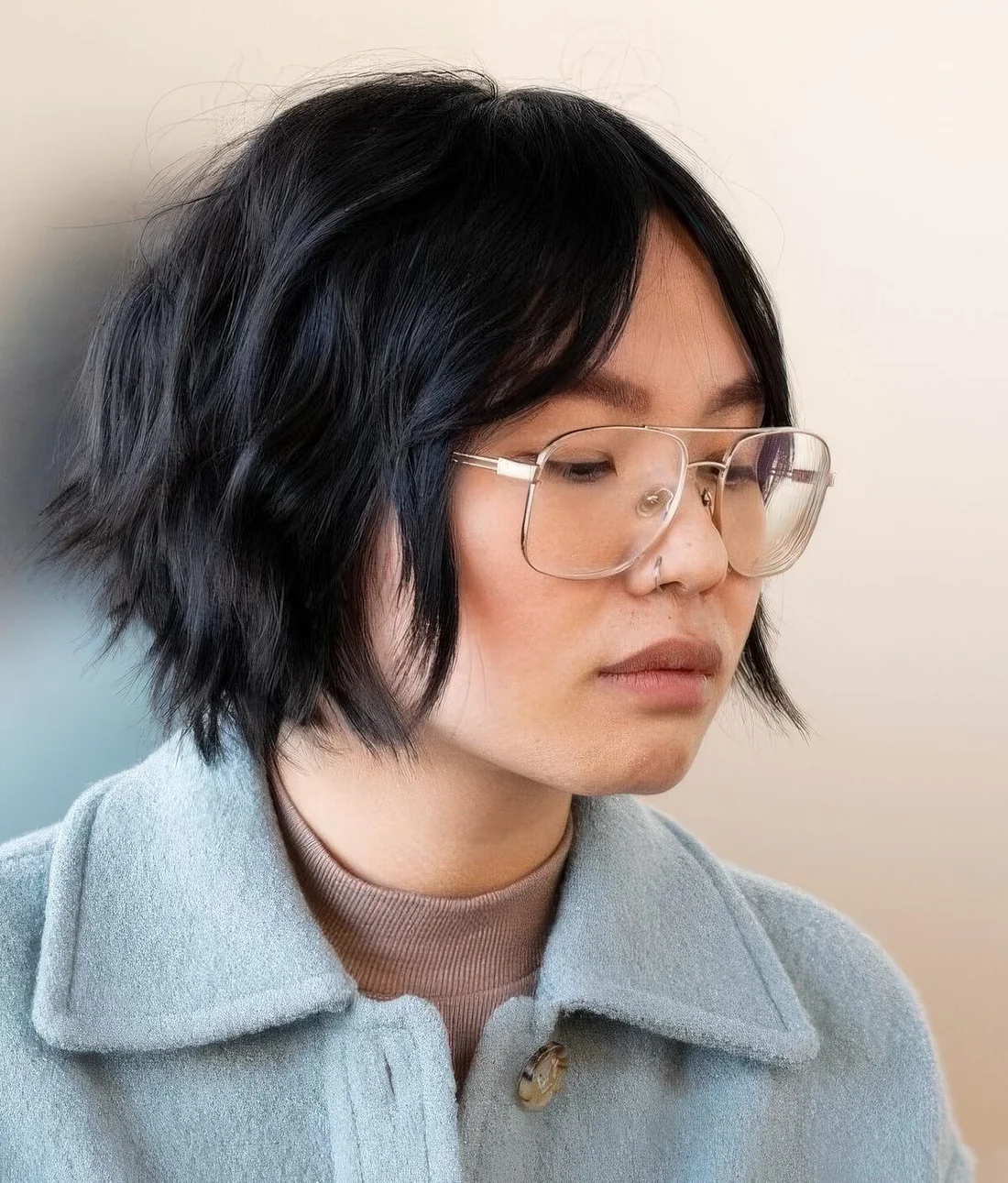 Graduated bob haircut in black, with curtain bangs.