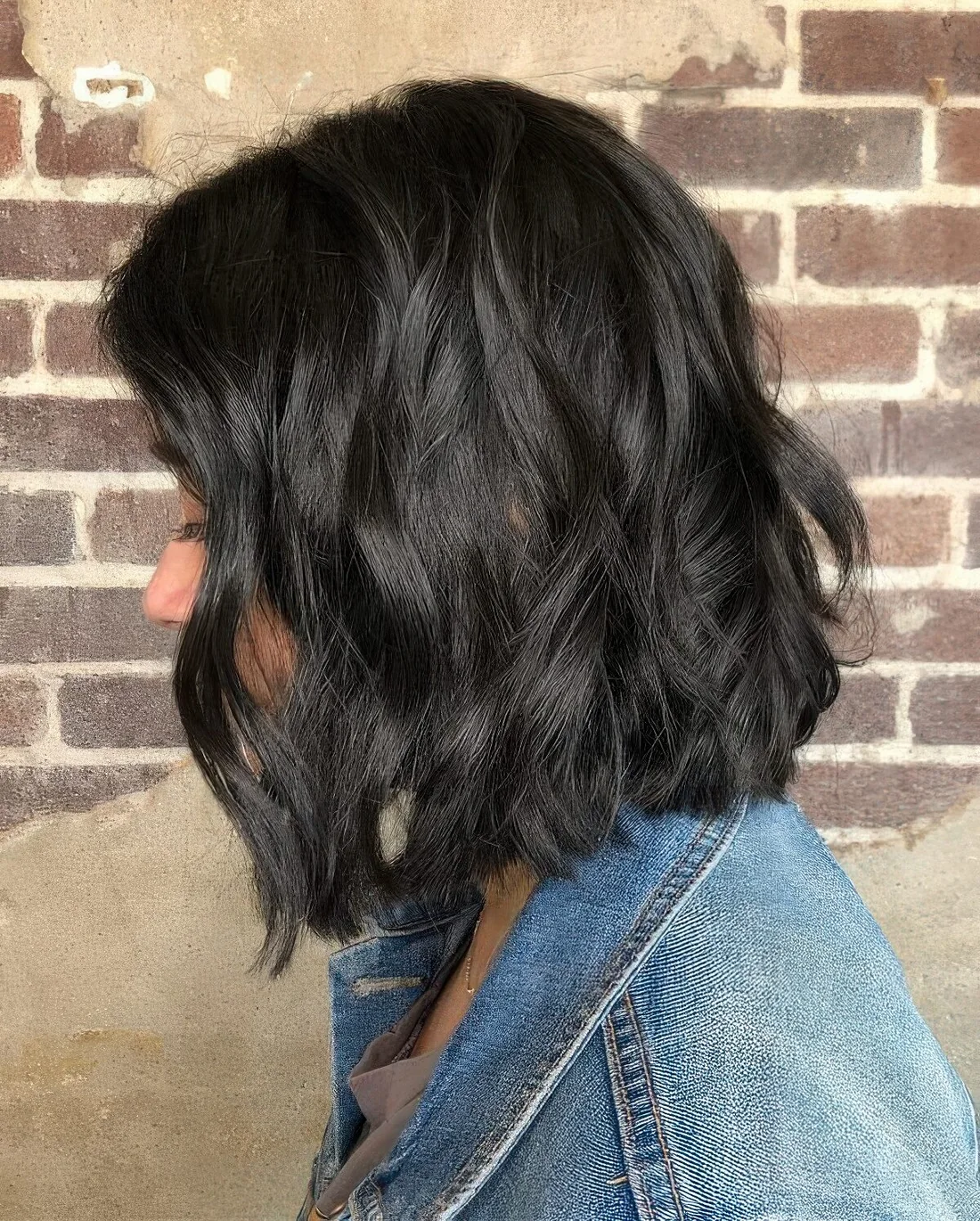 Long black bob with elegant waves and a shiny finish.