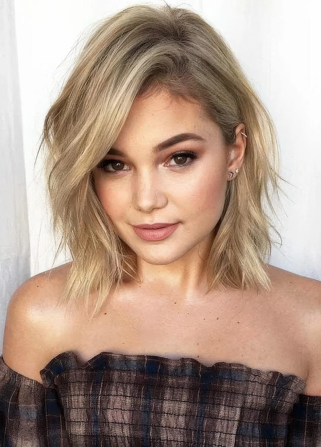 Blonde layered collarbone bob with a messy part and some waves.