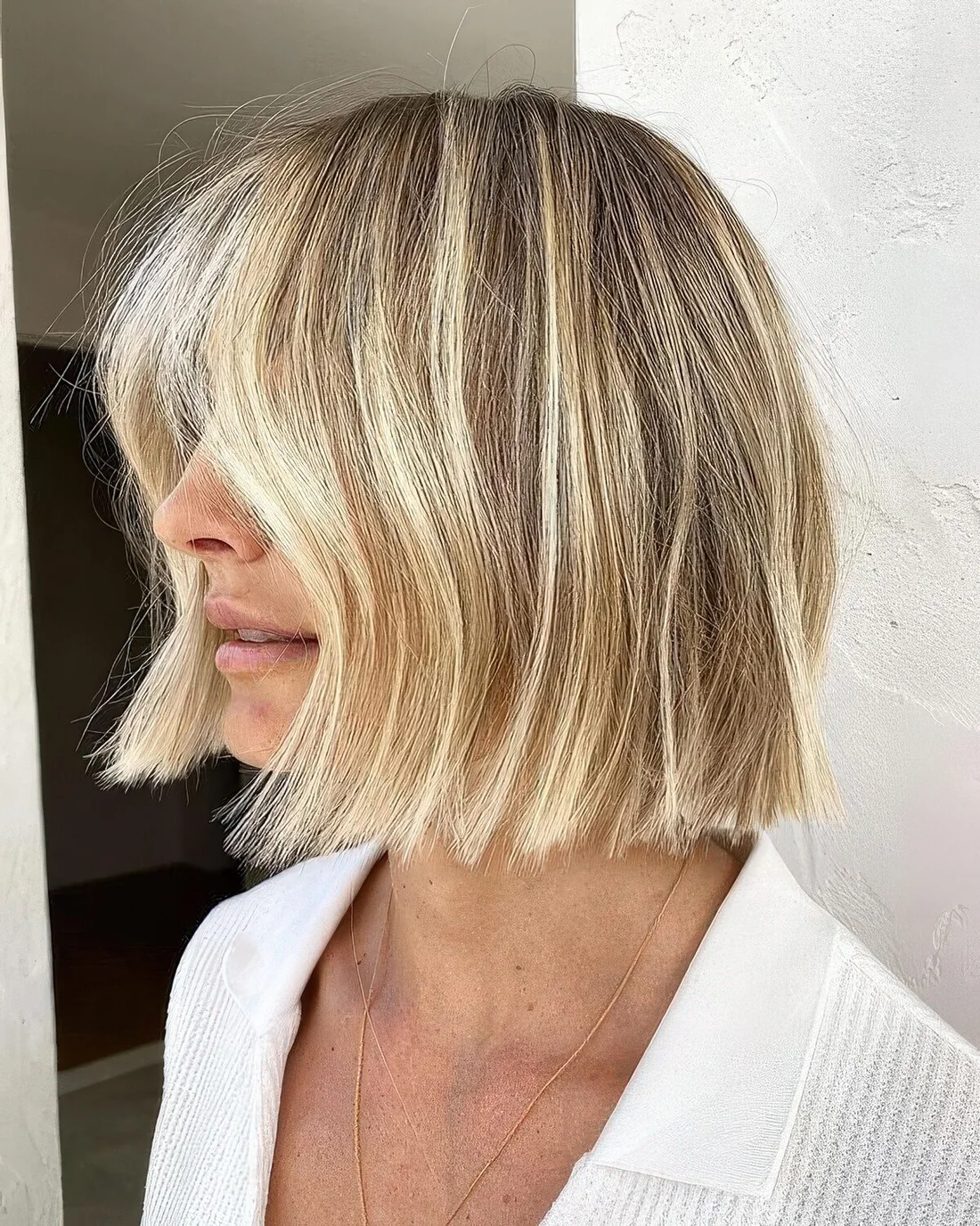 Golden blonde midi bob with wavy face-framing hair.