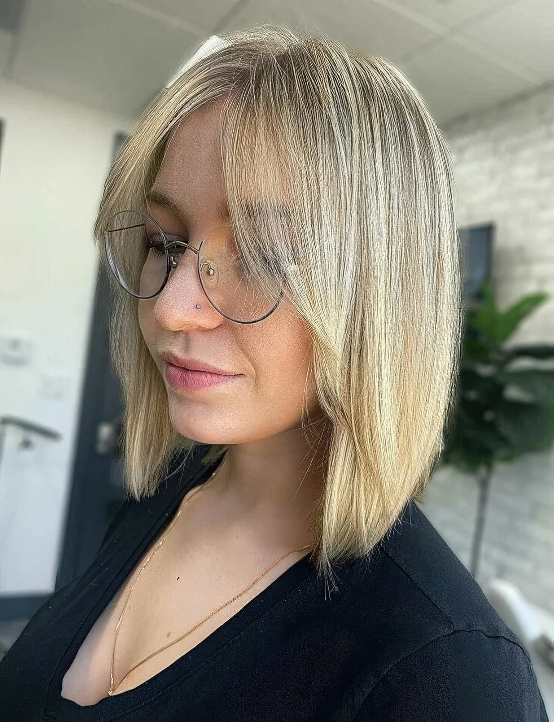 Photo showing blonde lob with curtain bangs, with the hairstyle clearly visible.