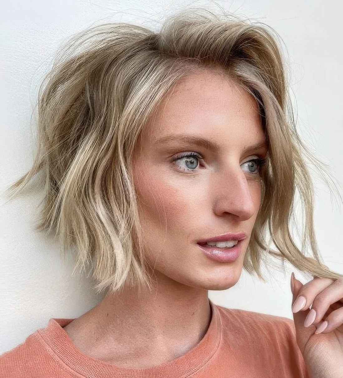 Textured wavy chin-length bob with a darker root.