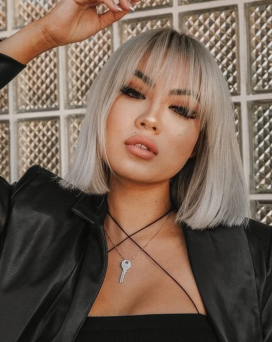Platinum blonde straight long bob with wispy bangs.