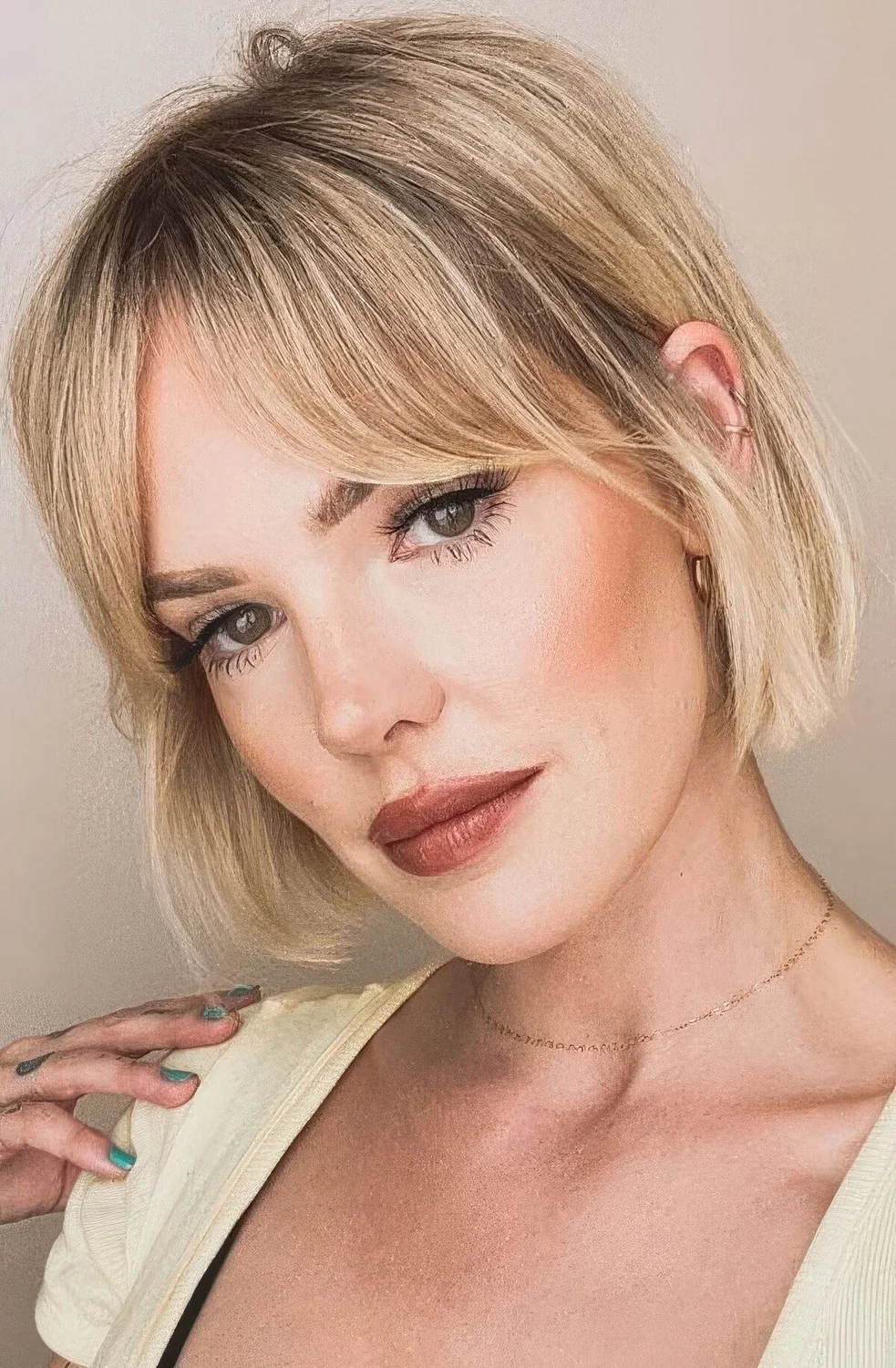 Blonde jaw-length bob with bottleneck bangs.