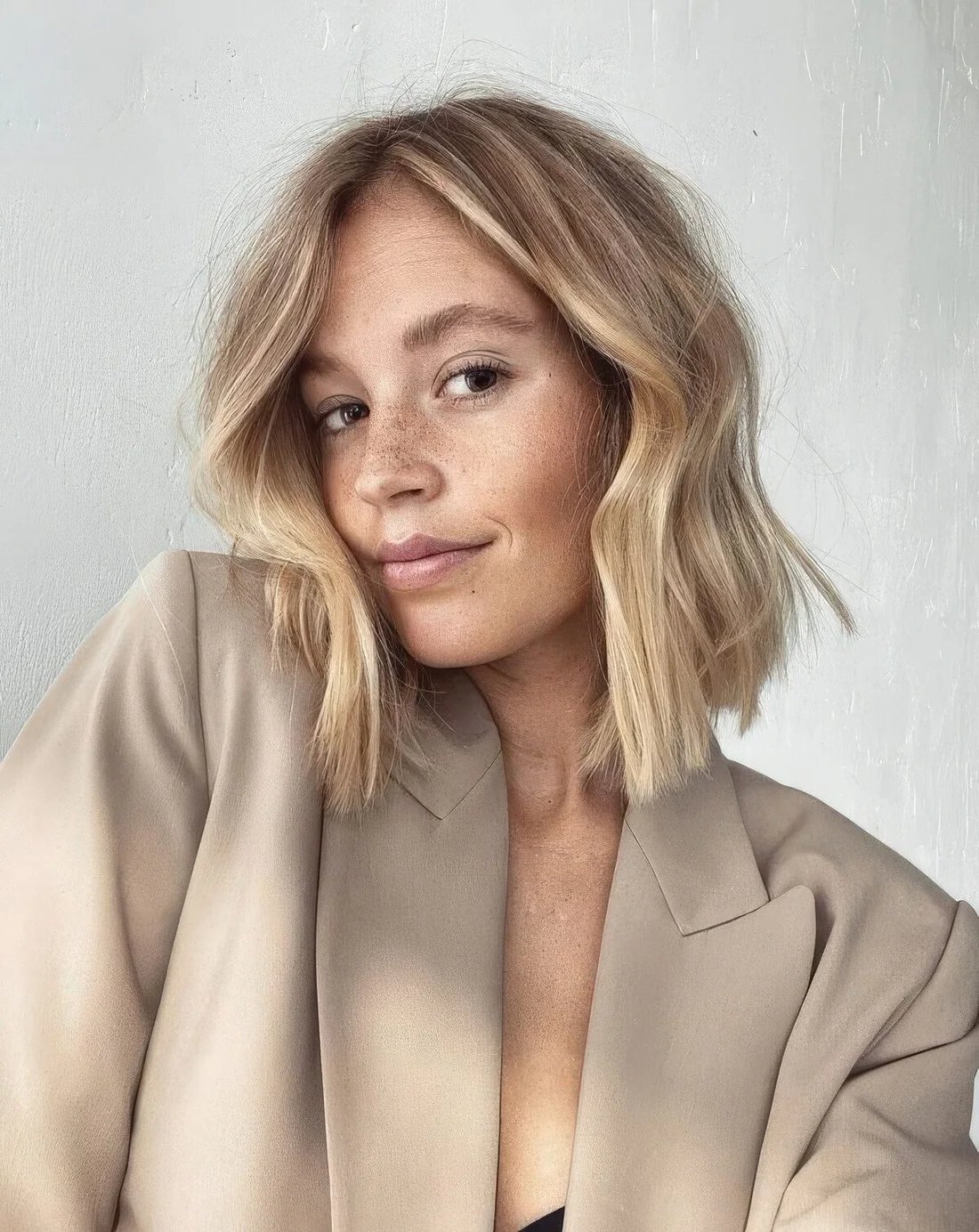 Photo showing long blonde bob with messy waves, with the hairstyle clearly visible.