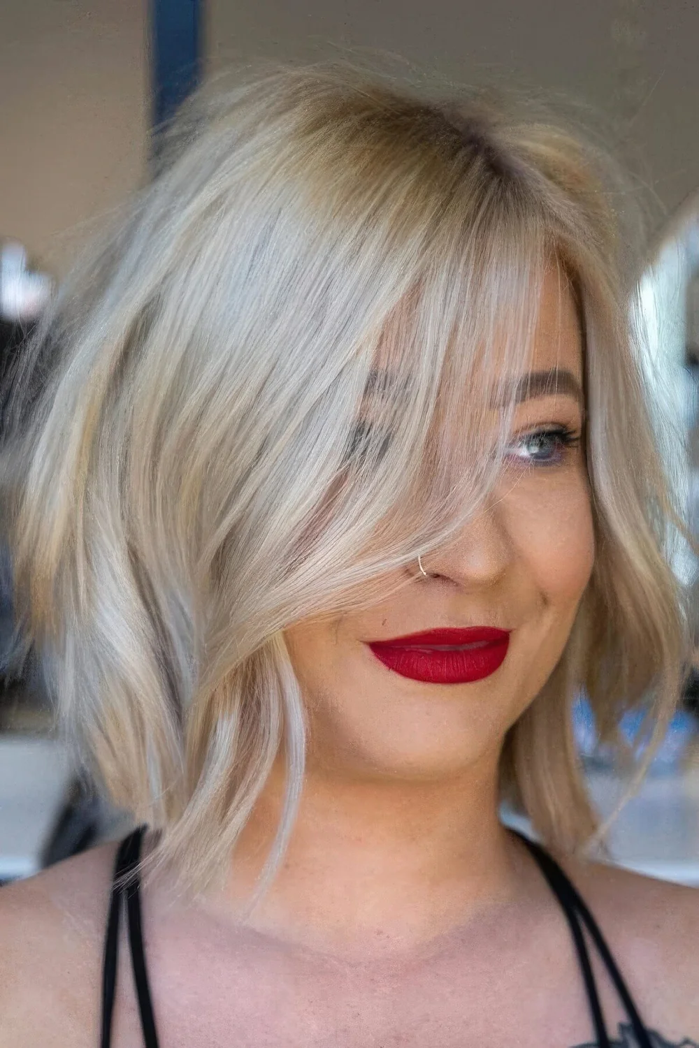 Long blonde bob with waves and a messy texture.