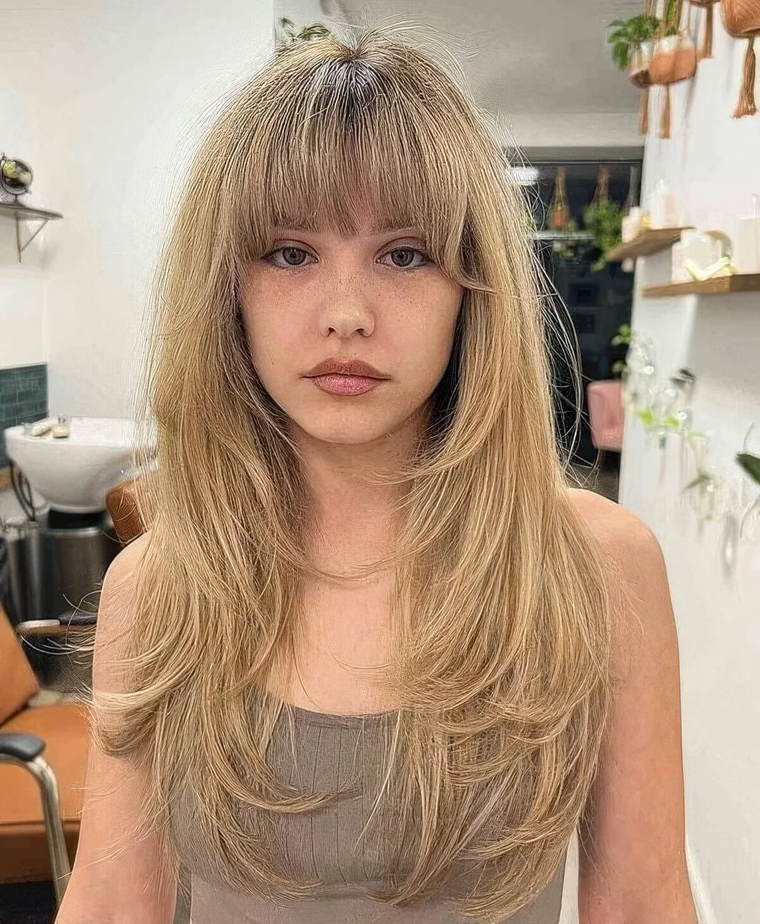 Buttefly haircut done on honey blonde hair with layered bangs and a lot of feathered layers.