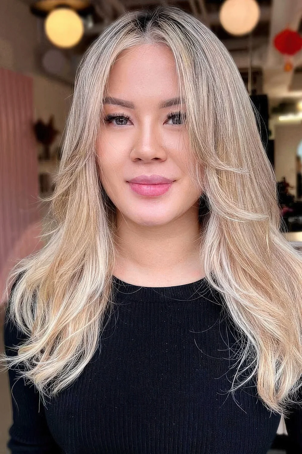 Bleached blonde butterfly haircut with wavy ends and a bit of texture.