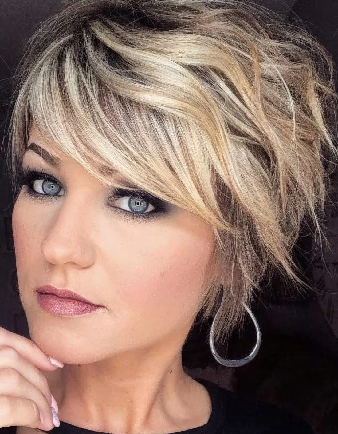 Blonde layered and shaggy pixie haircut with a darker root.