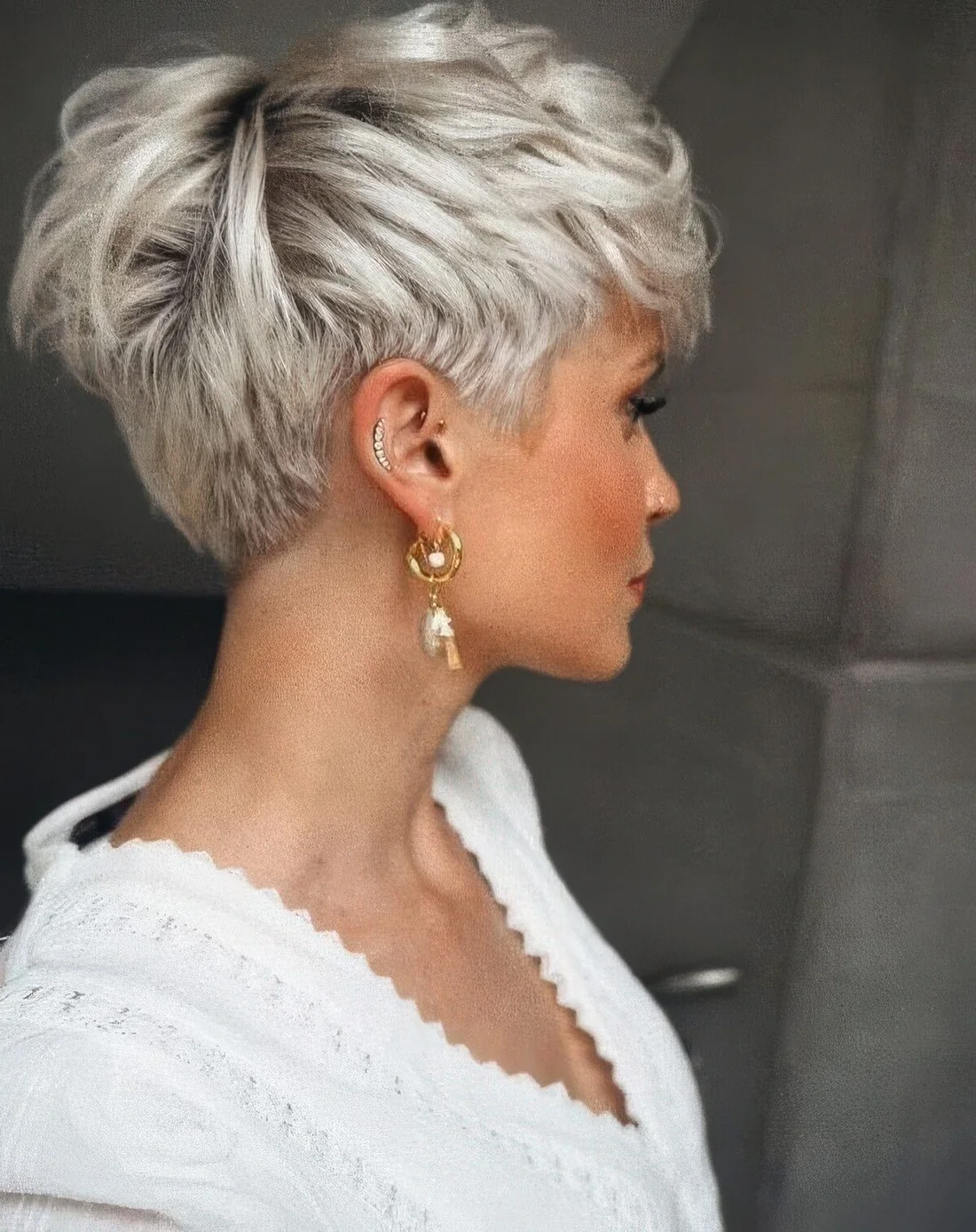 Ice blonde layered pixie cut with darker root.