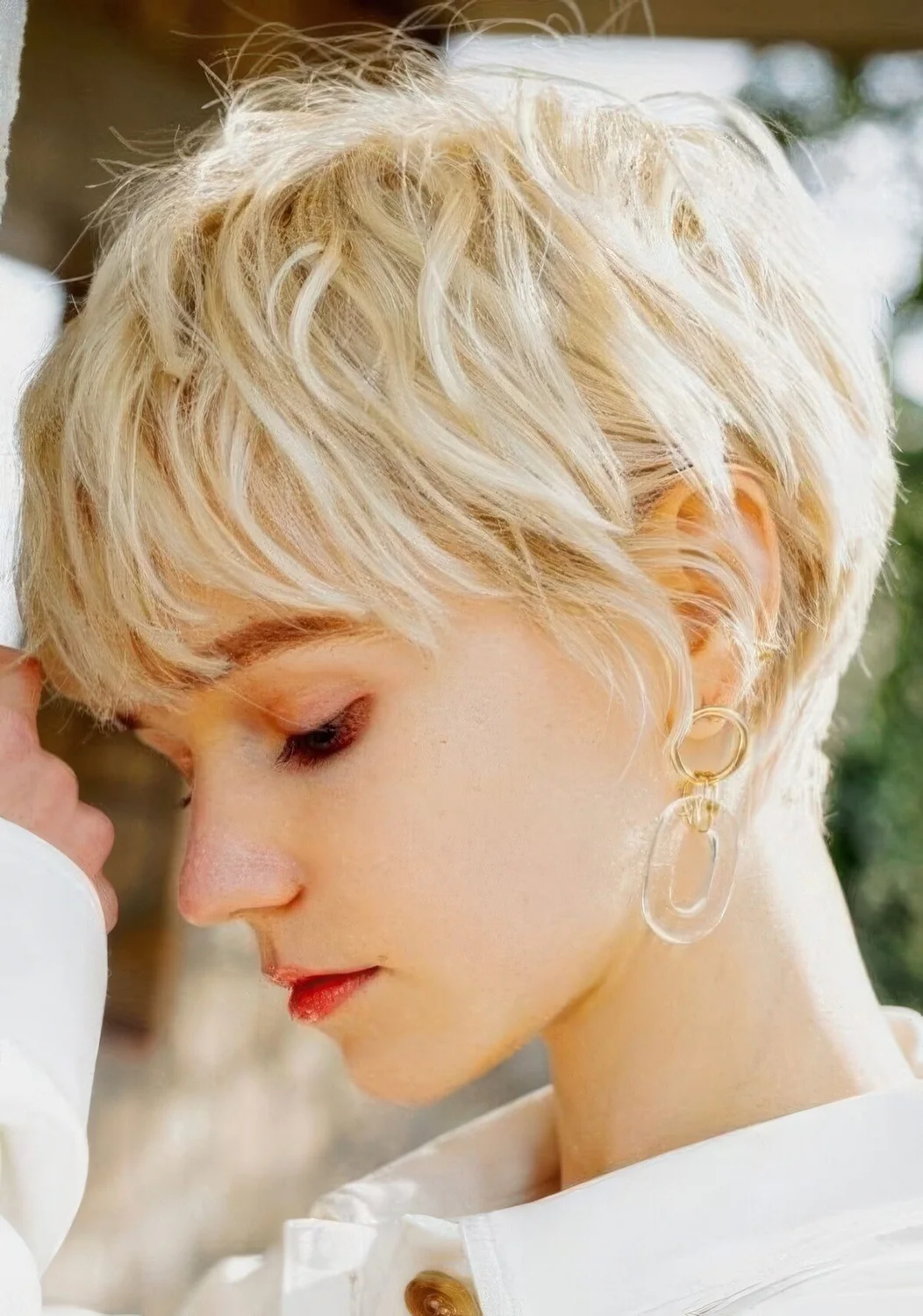 Messy creamy blonde layered pixie haircyt with feathered layers.