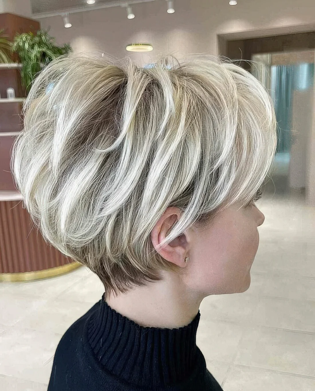 Icy blonde layered pixie bob with darker root.