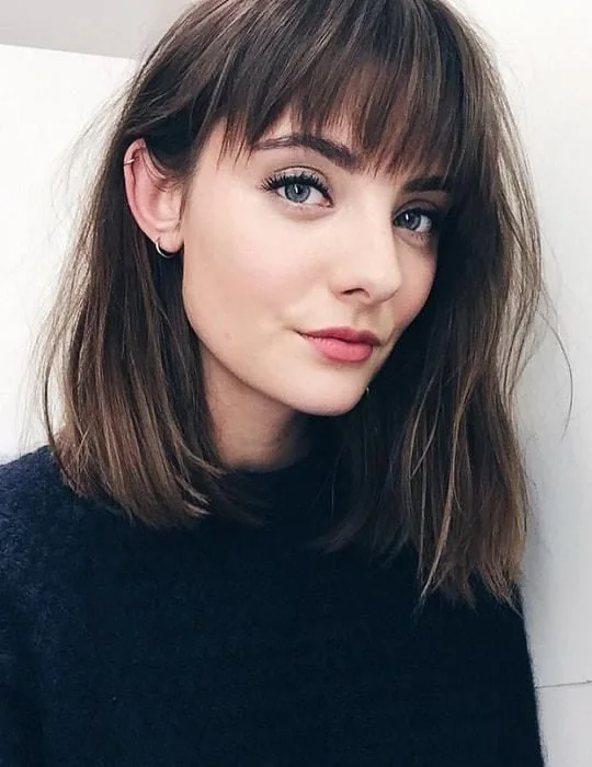 Shoulder-length brown bob with highlights, blunt bangs.
