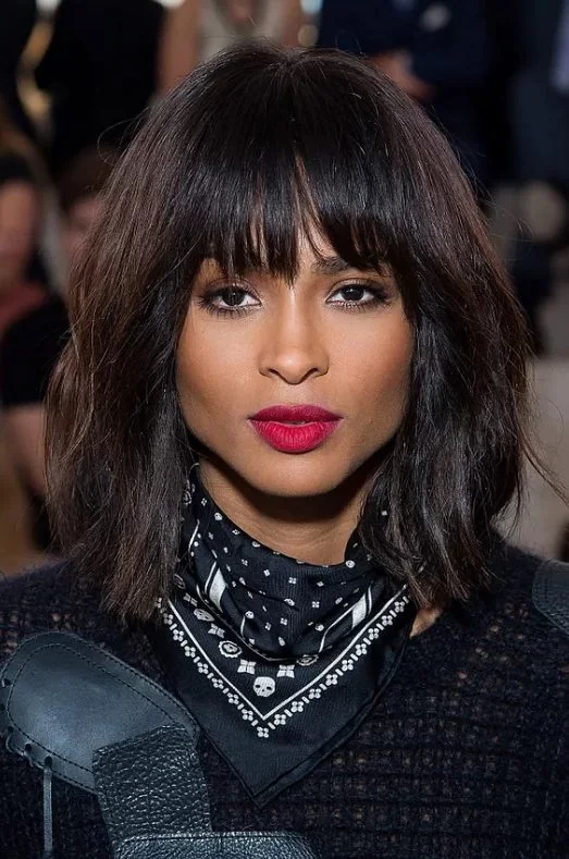 Ciara wearing a shaggy shoulder-length bob with messy waves, textured blunt bangs that accent her impressive cheekbones.